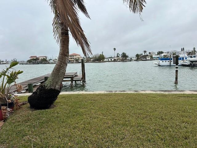 view of dock featuring a water view and a yard