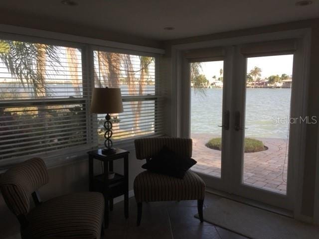 sunroom / solarium with a water view and a healthy amount of sunlight