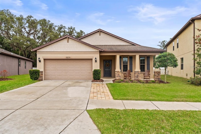 view of front of property with a porch, a garage, and a front lawn