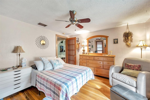 bedroom featuring hardwood / wood-style floors, a textured ceiling, and ceiling fan