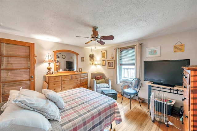 bedroom featuring a textured ceiling, light hardwood / wood-style flooring, and ceiling fan