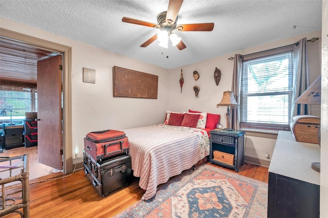 bedroom featuring a textured ceiling, ceiling fan, and light hardwood / wood-style flooring