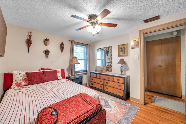 bedroom featuring a textured ceiling, ceiling fan, and light wood-type flooring