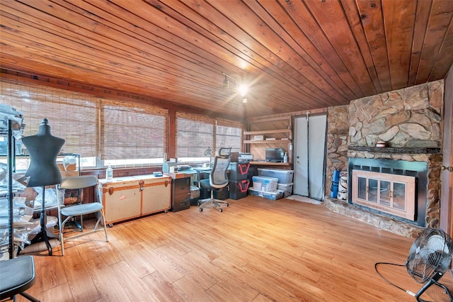 office space with wood ceiling, a fireplace, and light wood-type flooring