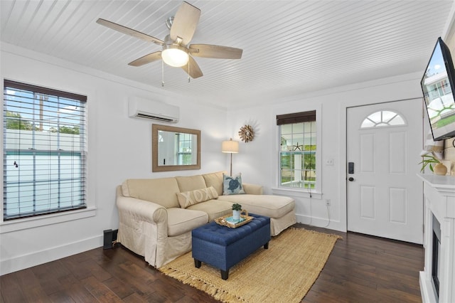 living room with dark wood-type flooring, an AC wall unit, and a healthy amount of sunlight