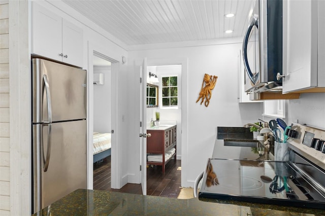 kitchen with sink, dark wood-type flooring, white cabinets, and appliances with stainless steel finishes