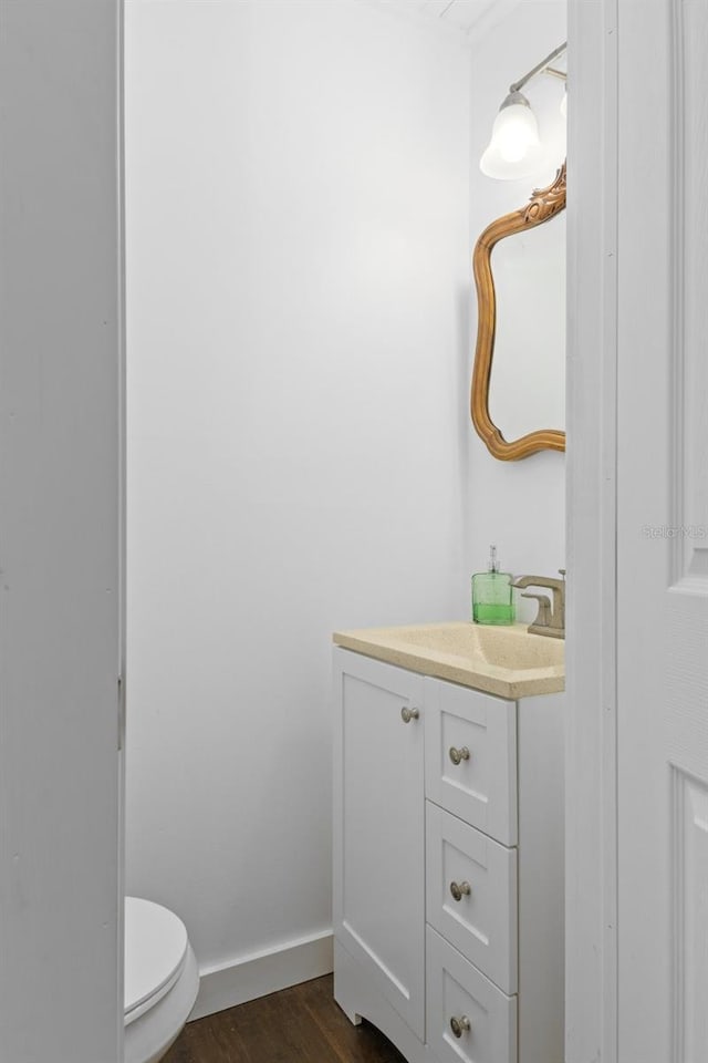 bathroom with hardwood / wood-style flooring, vanity, and toilet