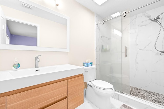 bathroom with vanity, a shower with shower door, and toilet