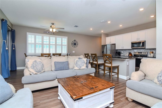 living room featuring ceiling fan and light wood-type flooring