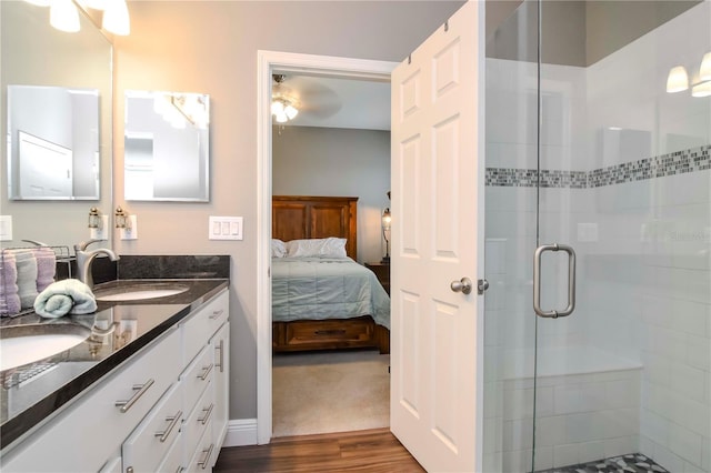 bathroom with vanity, hardwood / wood-style flooring, and a shower with door