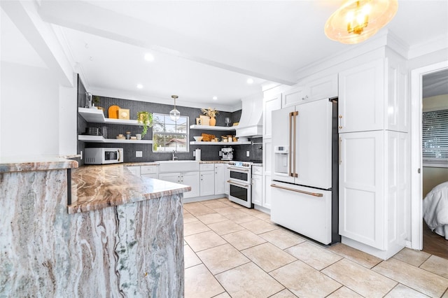 kitchen with premium range hood, high end fridge, white cabinets, decorative light fixtures, and range with two ovens