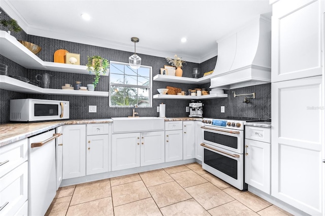 kitchen featuring pendant lighting, white appliances, premium range hood, ornamental molding, and white cabinets