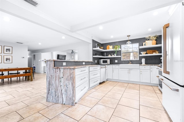 kitchen with kitchen peninsula, white cabinets, pendant lighting, white appliances, and backsplash