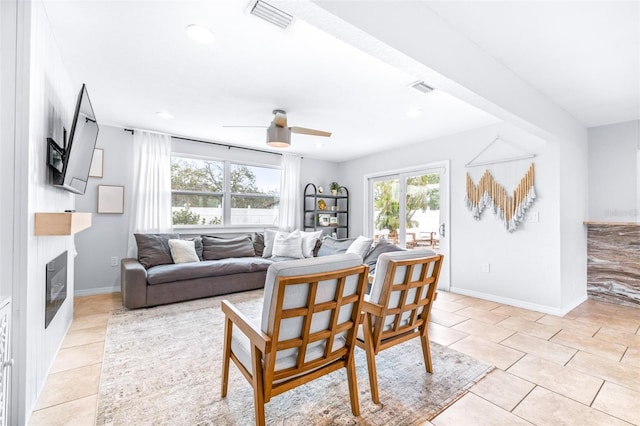 tiled living room featuring ceiling fan and a healthy amount of sunlight