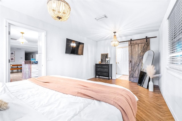 bedroom featuring a barn door and light parquet flooring