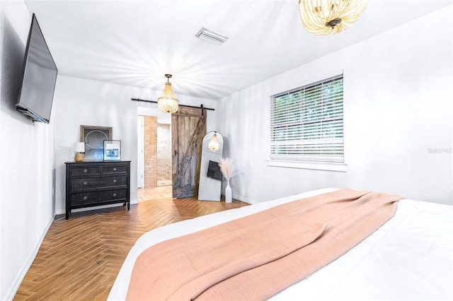 bedroom with a barn door and parquet floors