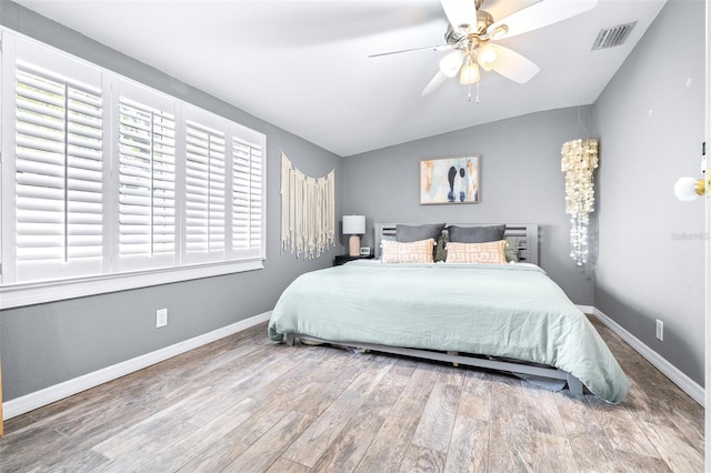 bedroom featuring hardwood / wood-style flooring, vaulted ceiling, and ceiling fan