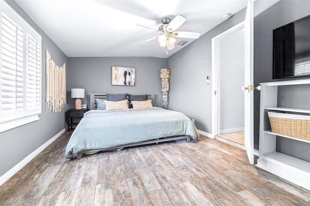 bedroom with lofted ceiling, hardwood / wood-style flooring, and ceiling fan