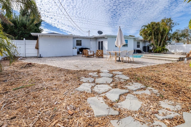 back of house with a fenced in pool and a patio