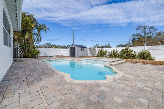 view of swimming pool with an in ground hot tub, a patio, and a shed