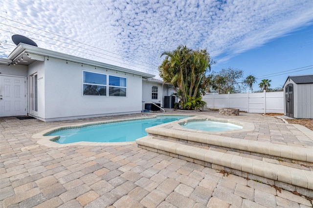 view of swimming pool featuring an in ground hot tub, a storage unit, cooling unit, and a patio