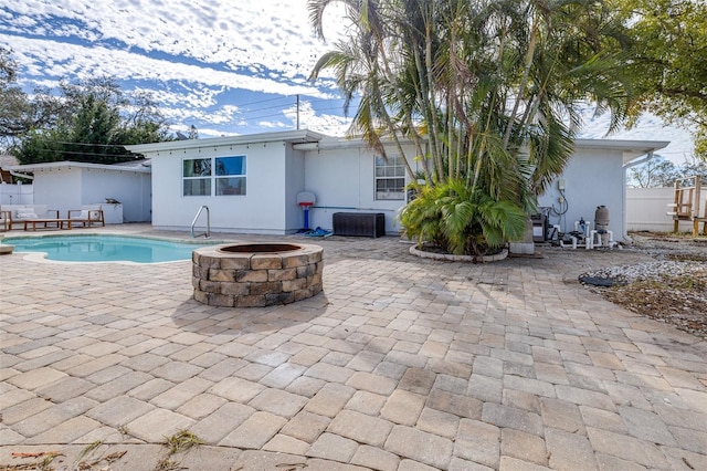 view of swimming pool featuring a patio area and a fire pit