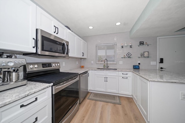 kitchen featuring white cabinetry, stainless steel appliances, light hardwood / wood-style floors, and sink