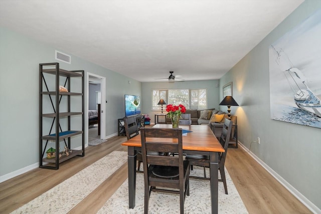 dining area with ceiling fan and light hardwood / wood-style flooring