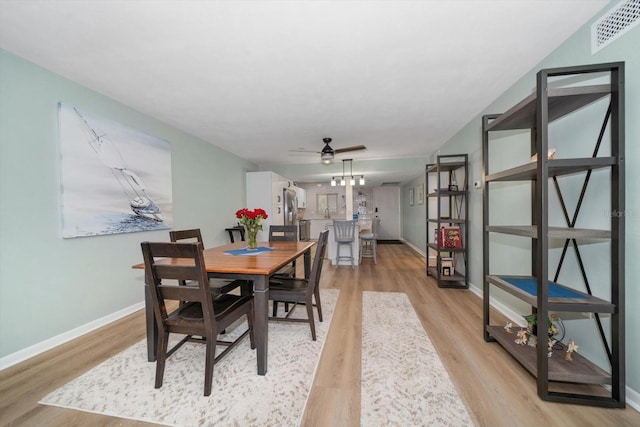 dining room with ceiling fan and light hardwood / wood-style flooring