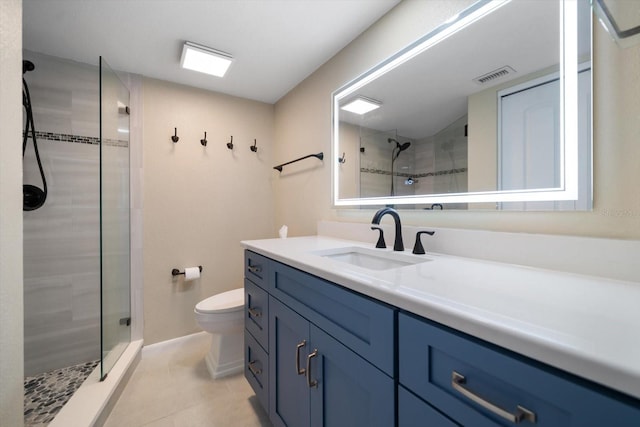 bathroom featuring vanity, tiled shower, tile patterned floors, and toilet