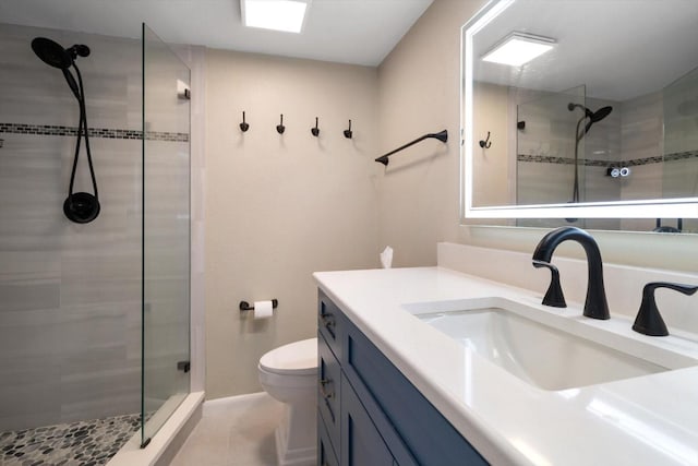 bathroom with vanity, tile patterned floors, toilet, and tiled shower