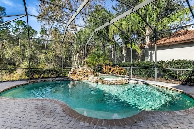 view of pool featuring an in ground hot tub and a lanai