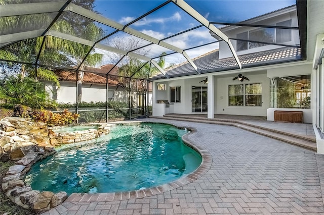 view of swimming pool with a lanai, ceiling fan, and a patio area