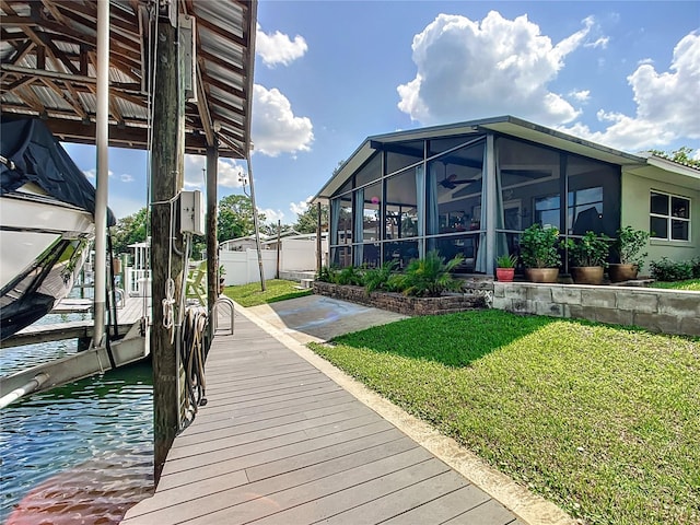 dock area with a lawn and a water view