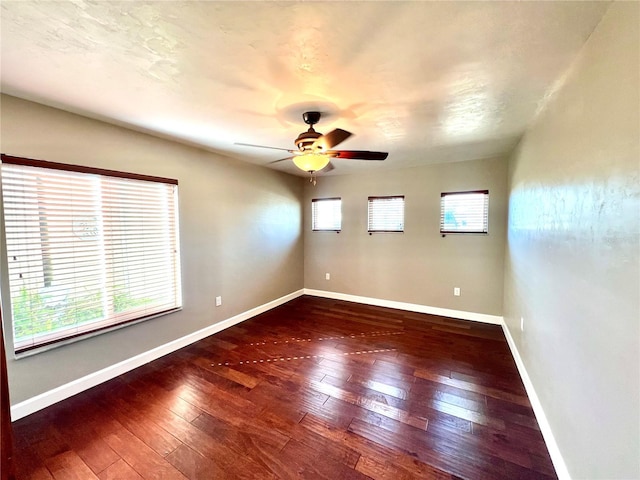 spare room with dark hardwood / wood-style flooring and ceiling fan