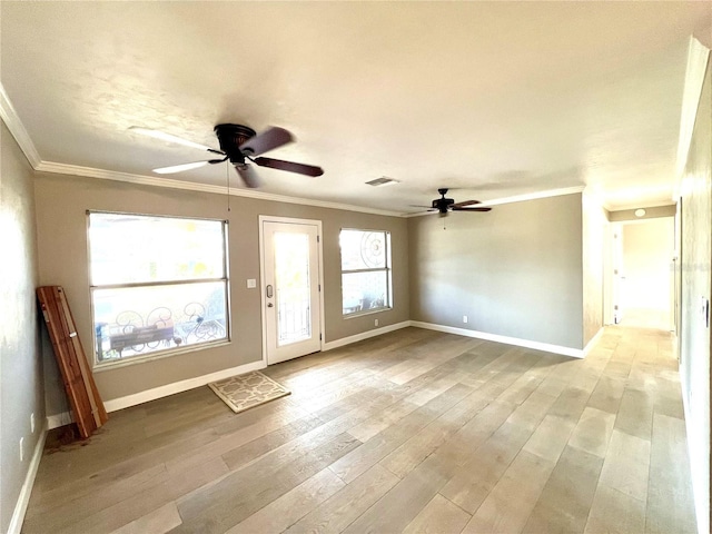 unfurnished room featuring crown molding, plenty of natural light, and light hardwood / wood-style floors