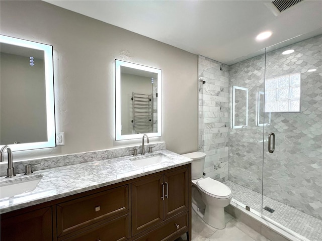 bathroom with tile patterned floors, vanity, toilet, and a shower with shower door