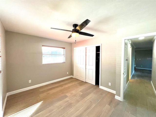 unfurnished bedroom with hardwood / wood-style flooring, ceiling fan, and a closet