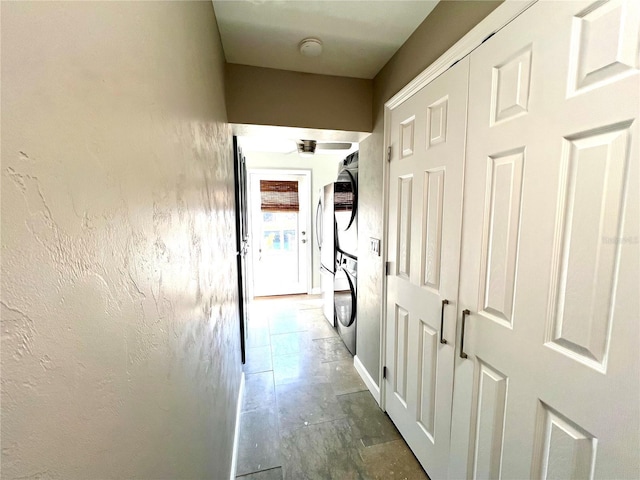 hallway with stacked washer and clothes dryer