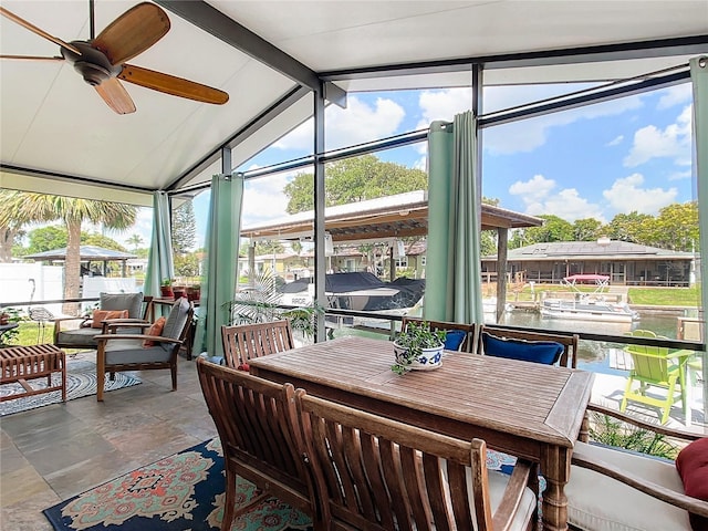 sunroom / solarium with lofted ceiling with beams, a water view, and ceiling fan