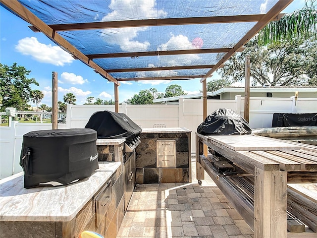 view of patio featuring area for grilling, a pergola, and exterior kitchen