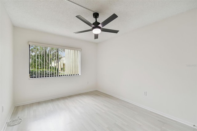 spare room featuring ceiling fan, light hardwood / wood-style floors, and a textured ceiling