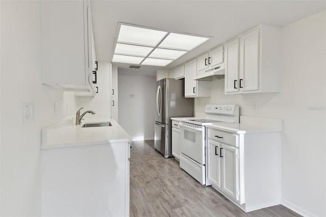 kitchen featuring electric stove, sink, stainless steel refrigerator, white cabinets, and light wood-type flooring