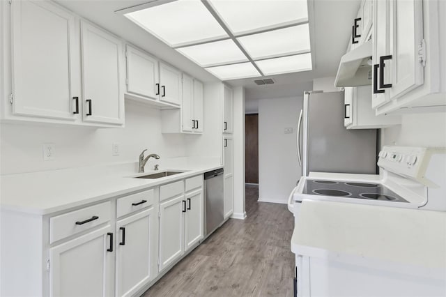 kitchen with white cabinetry, appliances with stainless steel finishes, sink, and light wood-type flooring