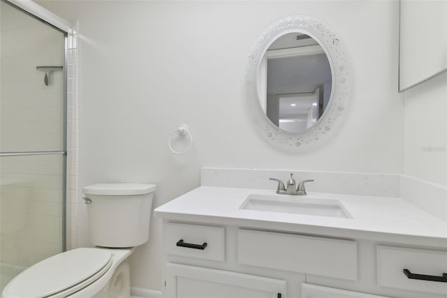 bathroom with a shower with door, vanity, and toilet