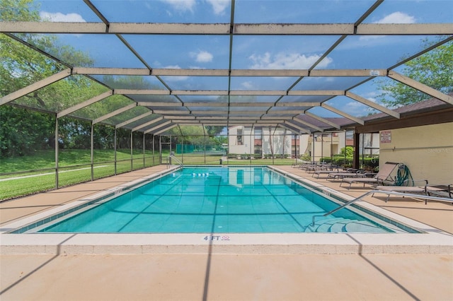 view of swimming pool with a lanai, a patio area, and a lawn