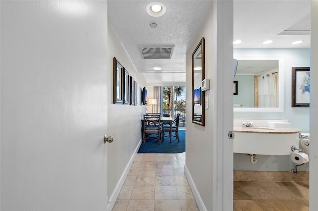 corridor featuring a textured ceiling