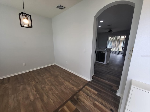 unfurnished room with dark wood-type flooring and ceiling fan