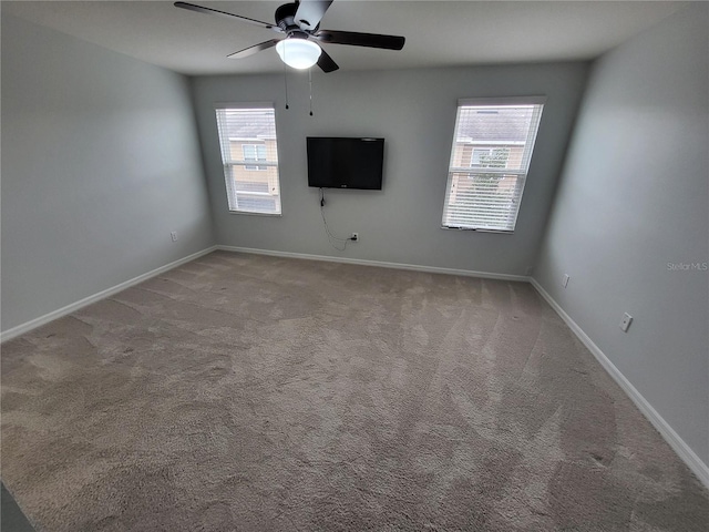 carpeted spare room featuring ceiling fan