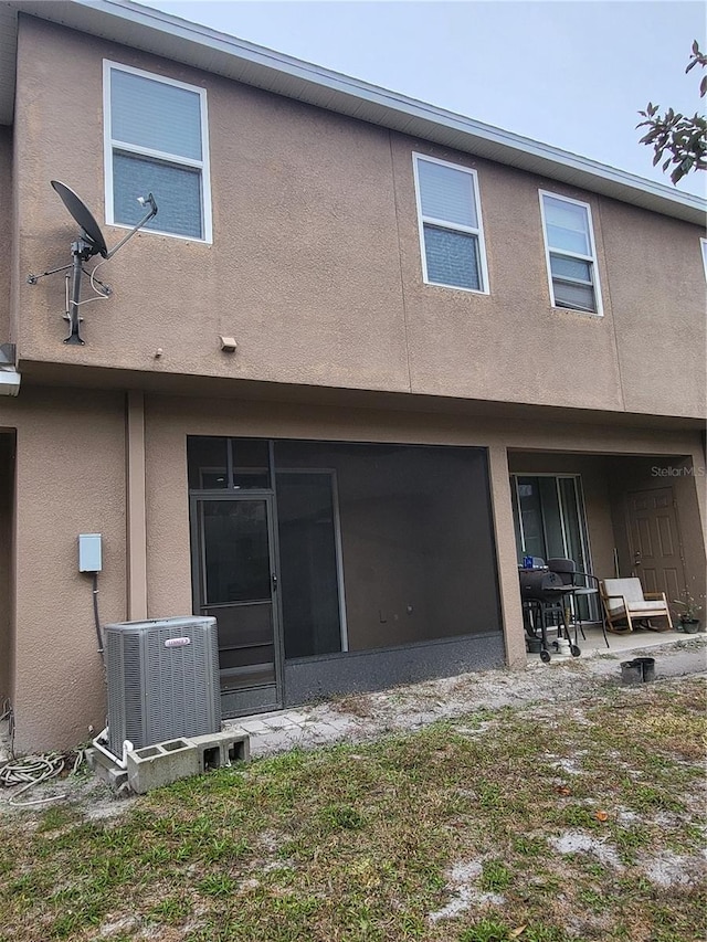 back of house with central AC unit